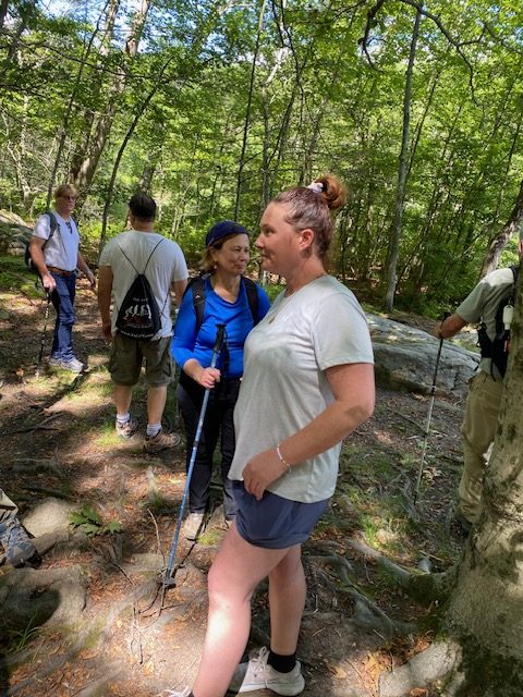 Hikers with trekking poles on a wooded climb